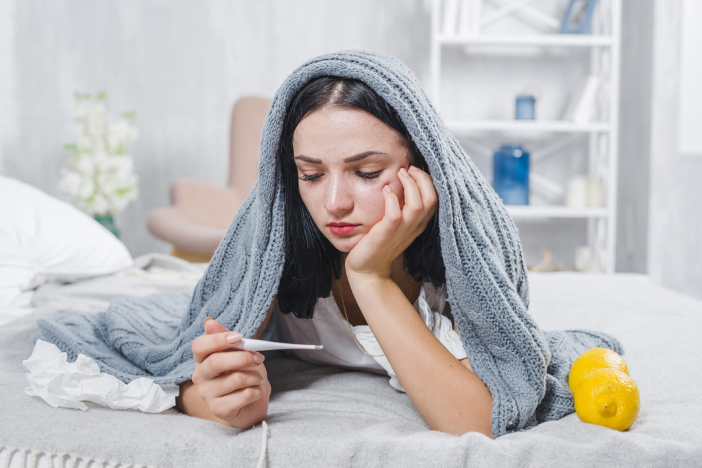 young-woman-with-scarf-around-her-head-checking-fever-with-thermometer.jpg